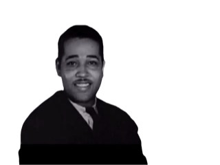 A  black and white film screen capture cutout of Duke Ellington as a young man wearing a suit and tie.
