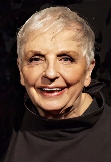 A color photograph of Carol Sloan with close cropped white hair wearing a black blouse late in her career.