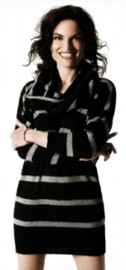 A color photograph of a full body shot of Roberta Gambarini in a black dress facing frontwards with a big smile.