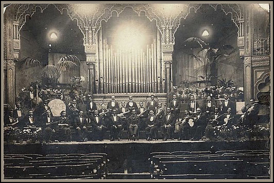 An old black and white photograph of the Southern Syndicated Orchestra in London, England around 1920.