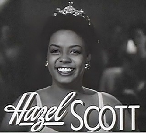 A black and white film screenshot of Hazel Scott's smiling head with her name written at bottom.