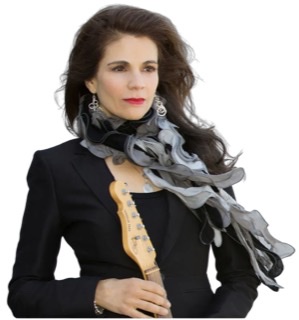 A color photograph of a Joyce Cooling holding the neck of her upright guitar.