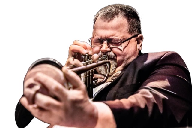 A colorized photographic cutout of Beka Szaloky with eyes squeezed shut blowing hard through his trumpet while holding a mute in trumpet bell.