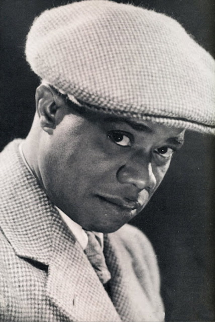 Headshot of Louis Armstrong wearing a cap.
