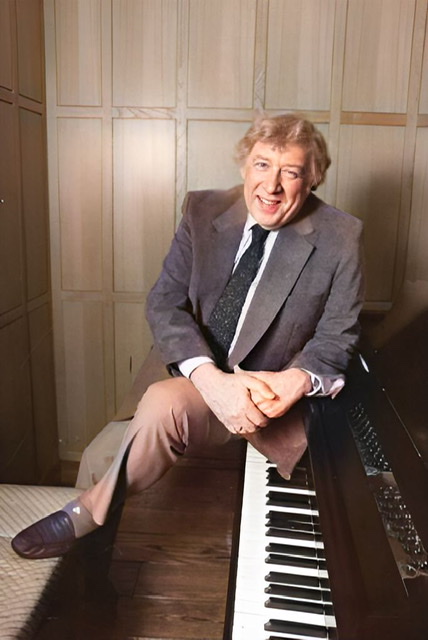 A colorized photograph of Gunther Schuller wearing a coat and tie while sitting on a piano with his foot on the piano bench.