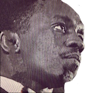 A black and white photograph of a closeup of Art Blakey's head in right profile.