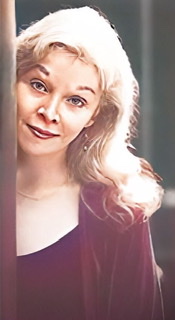 An enhanced and colorized headshot of Jessica Williams looking straightforward with her hair cascading down here left shoulder and her right shoulder hidden behind a post.